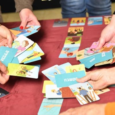 אנשים מחזיקים בקלפים מעל שולחן